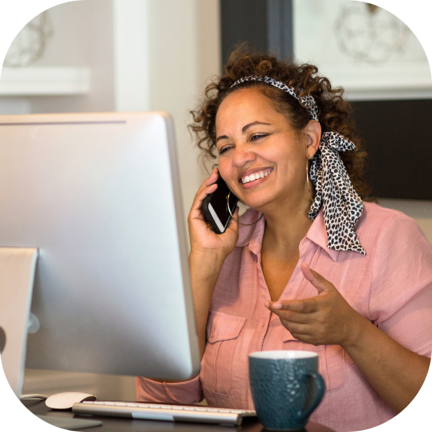 A woman taking advantage of software solutions on her computer while on the phone